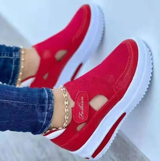 Red platform slip-on sneakers with cutout details, gold chain anklet, and white sole — stylish casual footwear