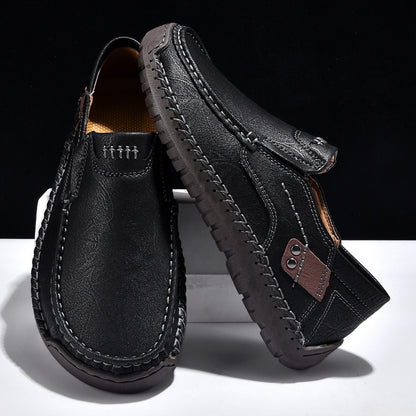 Black leather loafers with contrast stitching and brown accent, minimalist men's footwear