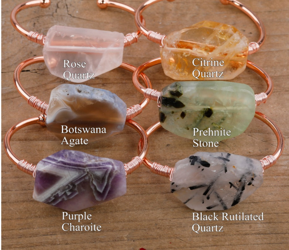 Handcrafted gemstone bangles with Rose Quartz, Citrine, Agate, Prehnite, Charoite, and Rutilated Quartz on wood