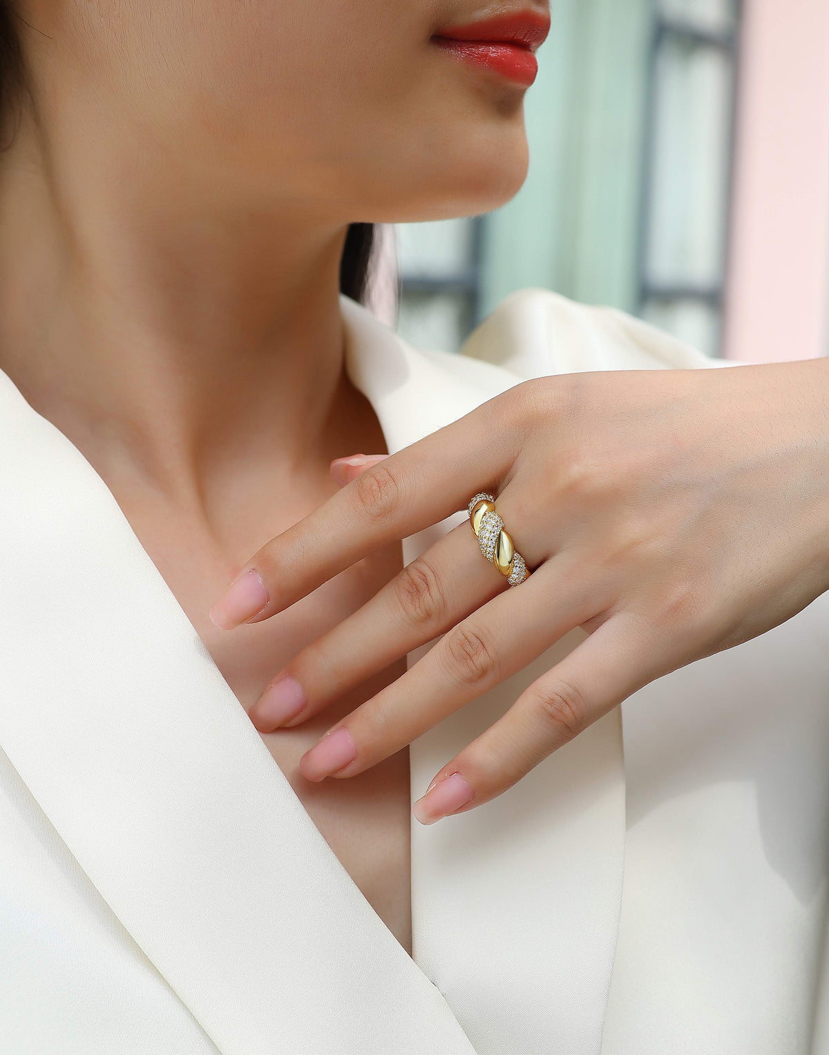 Elegant gold ring with sparkling stones on woman's hand, minimalist luxury jewelry