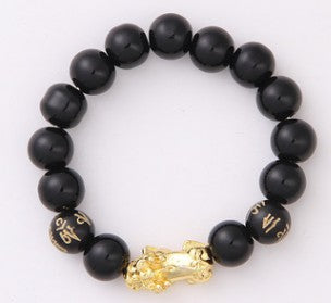 Black beaded bracelet with gold Buddha charm and engraved beads, minimalist luxury jewelry design