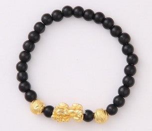 Black beaded bracelet with gold lion charm, minimalist luxury jewelry design