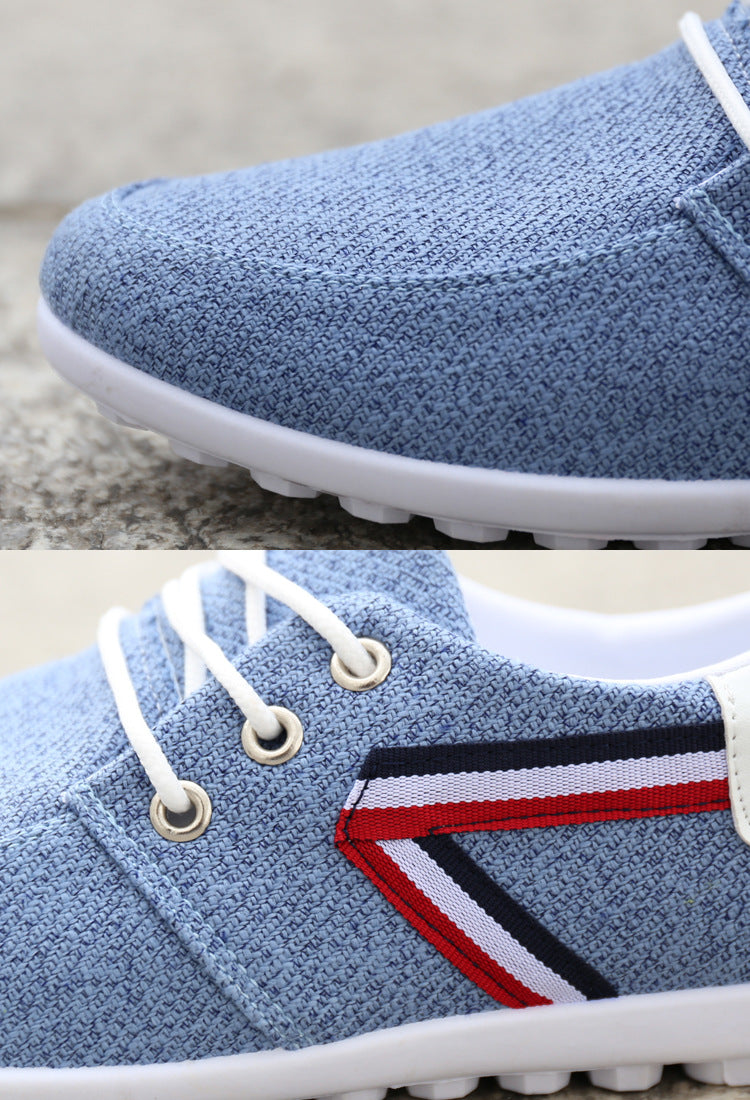 Light blue canvas sneaker with white laces, red-white-black stripe, and white sole — minimalist design