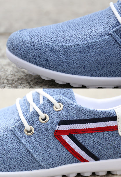 Light blue canvas sneaker with white laces, red-white-black stripe, and white sole — minimalist design