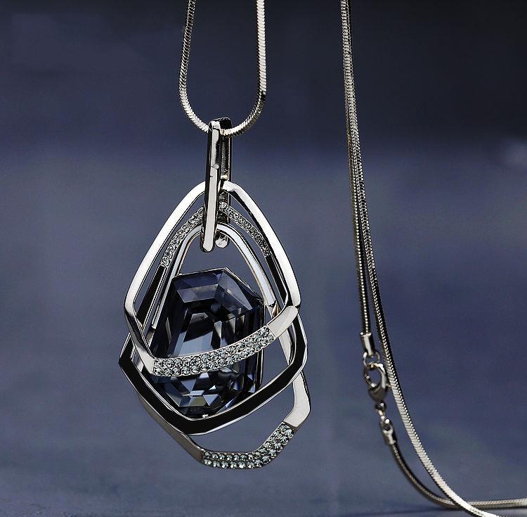 Luxury pendant necklace with geometric silver frame, faceted dark gemstone, and diamond accents on snake chain.