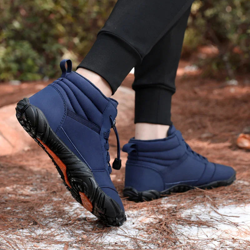 Navy blue high-top outdoor boots with rugged sole, worn on snowy trail