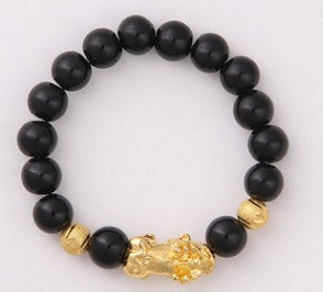 Black onyx beaded bracelet with gold lion charm, luxury minimalist jewelry design
