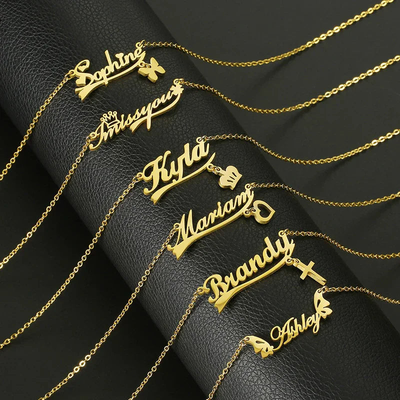Personalized gold name necklaces with custom script and charms on black leather display
