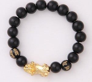 Black beaded bracelet with gold tiger charm, minimalist luxury jewelry design