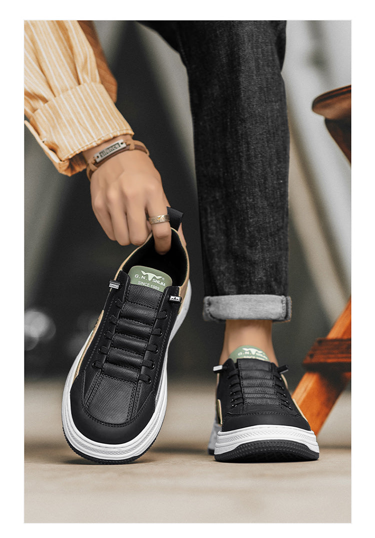 Black minimalist sneakers with white sole, gold accents, and green heel tab, worn with cuffed jeans