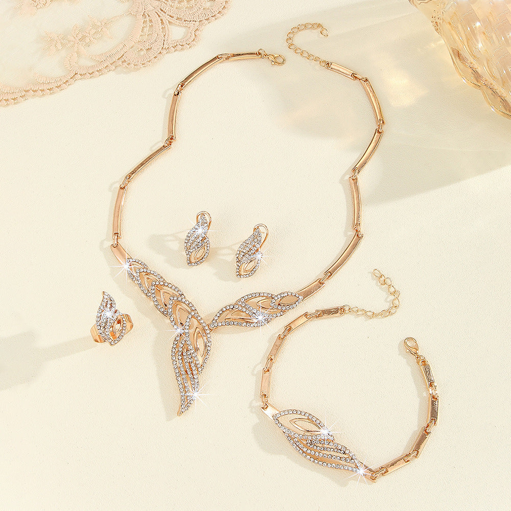 Luxury rose gold jewelry set with crystal-embellished leaf design necklace, earrings, ring, and bracelet