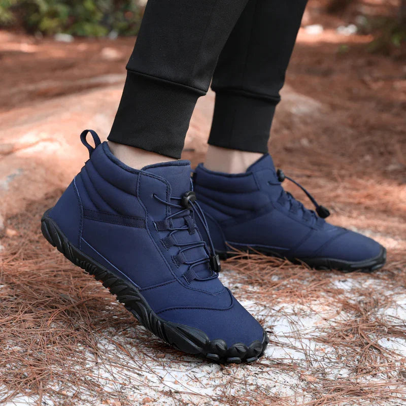 Navy blue minimalist hiking boots with rugged sole, worn on forest trail, handcrafted design