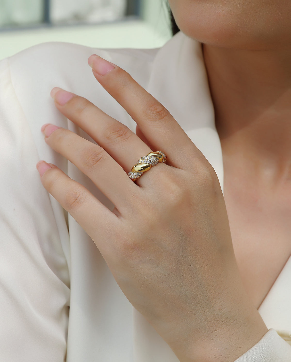 Gold ring with diamond accents on woman's hand, minimalist luxury jewelry design