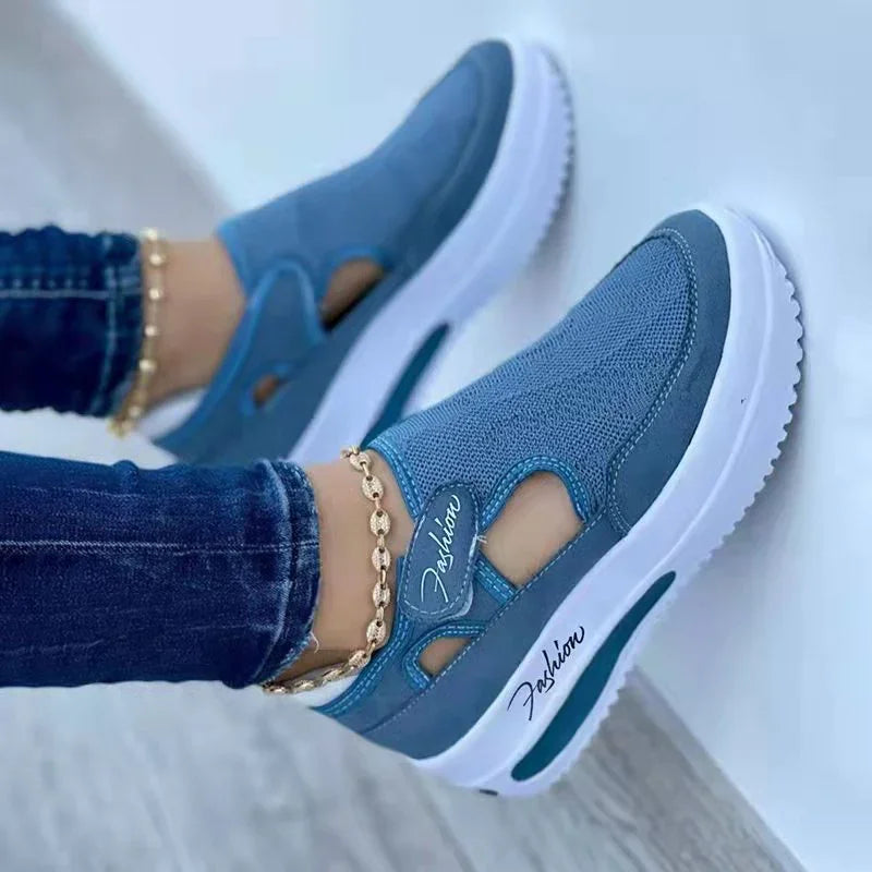 Blue slip-on platform sneakers with 'Fashion' script, white sole, worn with jeans and gold anklet