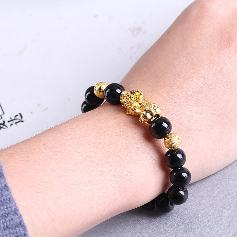 Black onyx beaded bracelet with gold lucky cat charm, minimalist luxury jewelry design