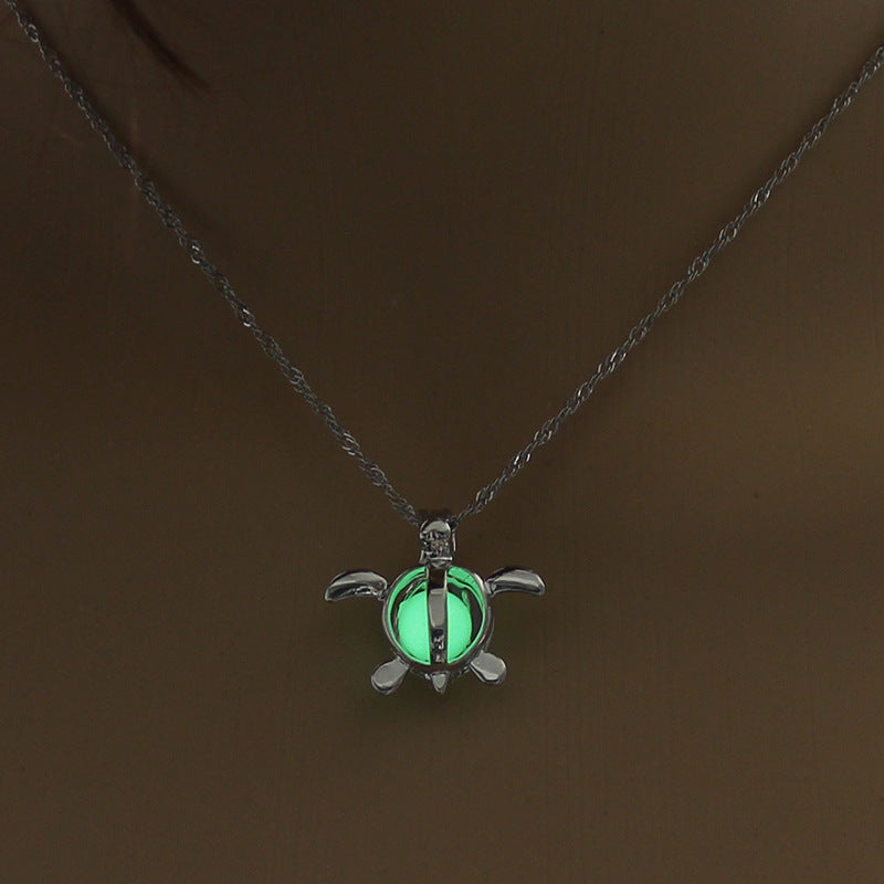 Glowing turtle pendant necklace with luminous green shell, minimalist silver chain design