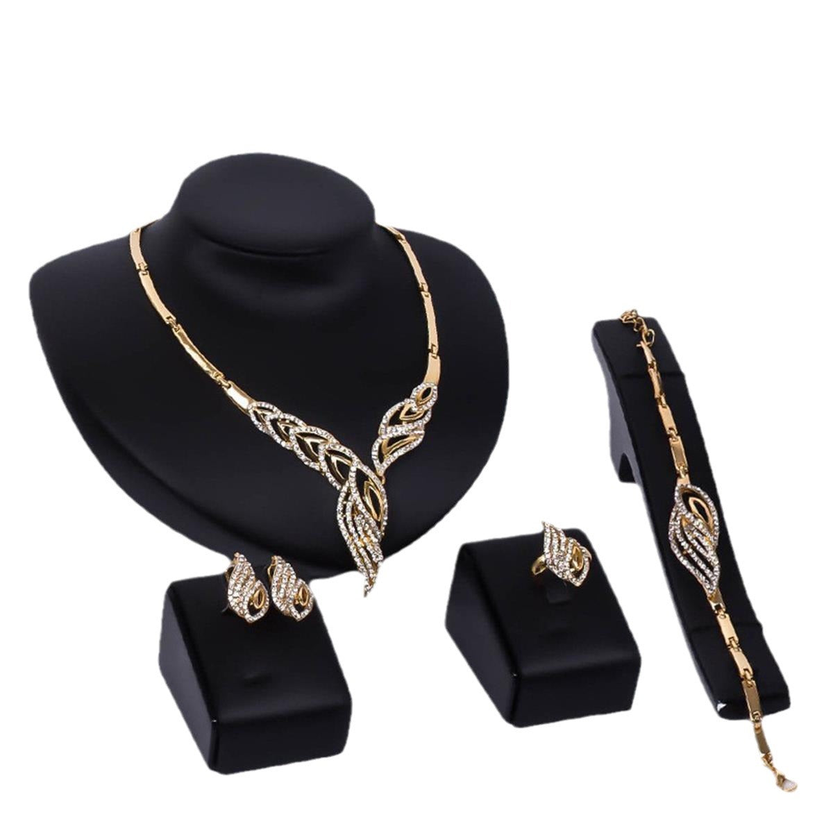 Elegant gold-tone jewelry set with crystal-embellished necklace, earrings, ring, and bracelet on black display stands
