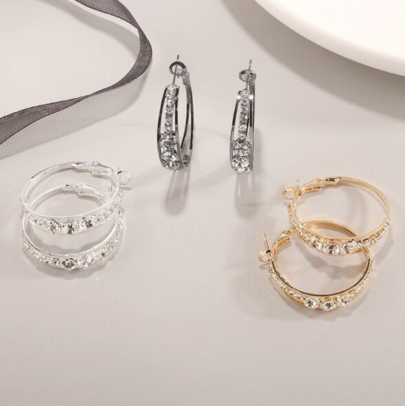 Elegant crystal-embellished hoop earrings in silver and gold tones, minimalist luxury jewelry design