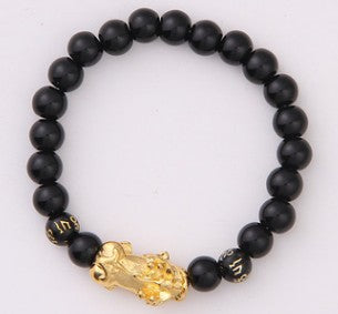 Black beaded bracelet with gold lion charm, minimalist luxury jewelry design