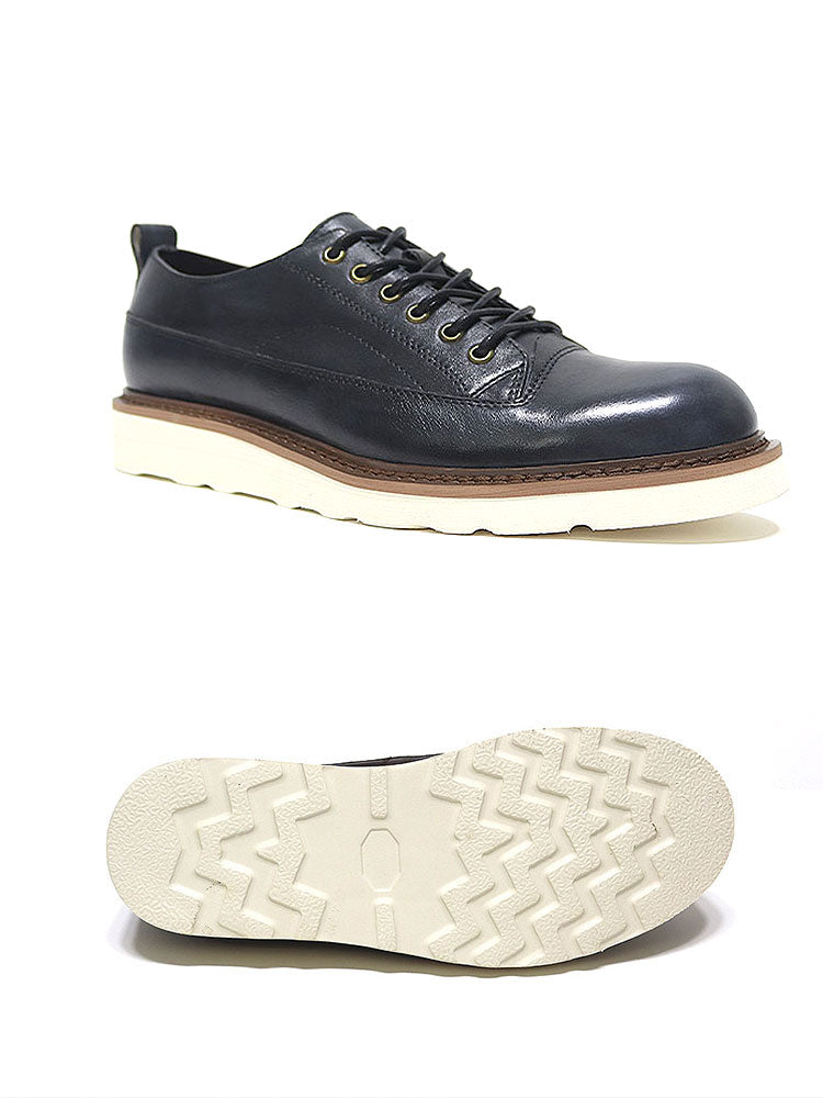Black leather lace-up shoe with white sole and zigzag tread, minimalist design