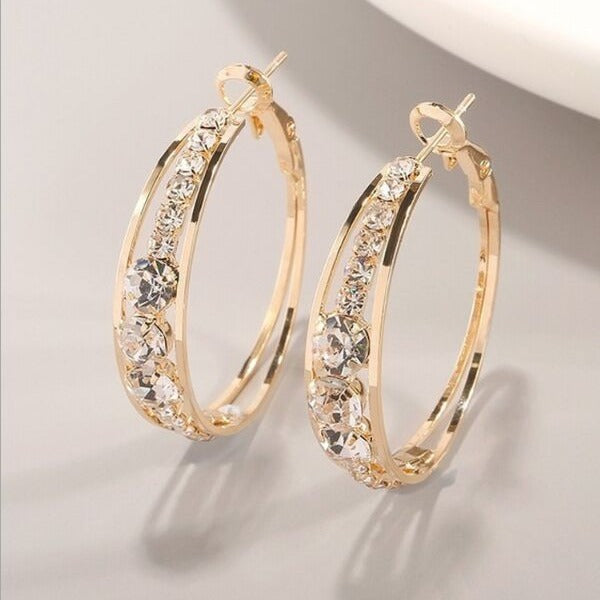 Gold hoop earrings with sparkling crystal accents, minimalist luxury jewelry design