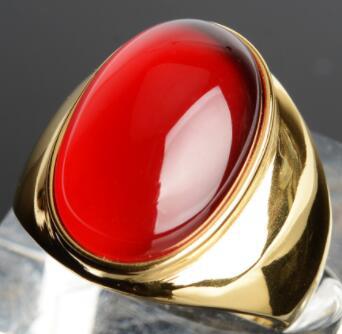 Luxury gold ring with vibrant red cabochon stone, minimalist design, premium craftsmanship