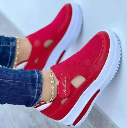 Red platform slip-on sneakers with cutout details, gold chain anklet, and white sole — stylish casual footwear