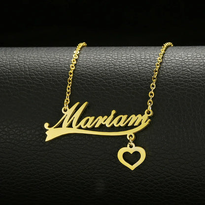 Gold name necklace with heart charm, personalized jewelry on black leather background