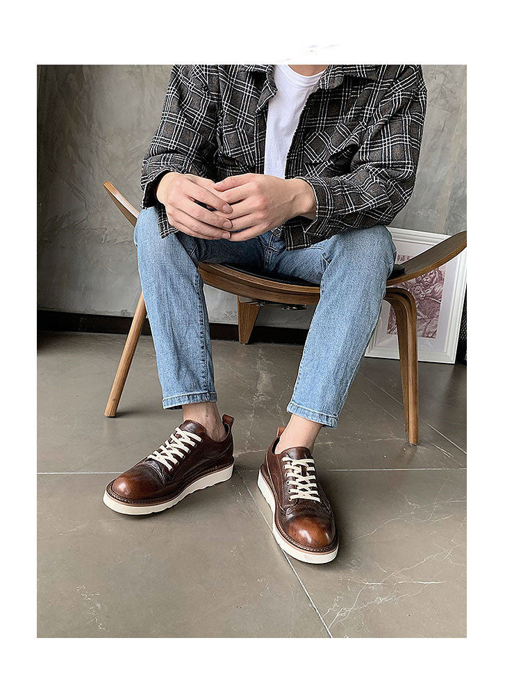Brown leather sneakers with white laces, styled with jeans and plaid shirt, minimalist men's footwear