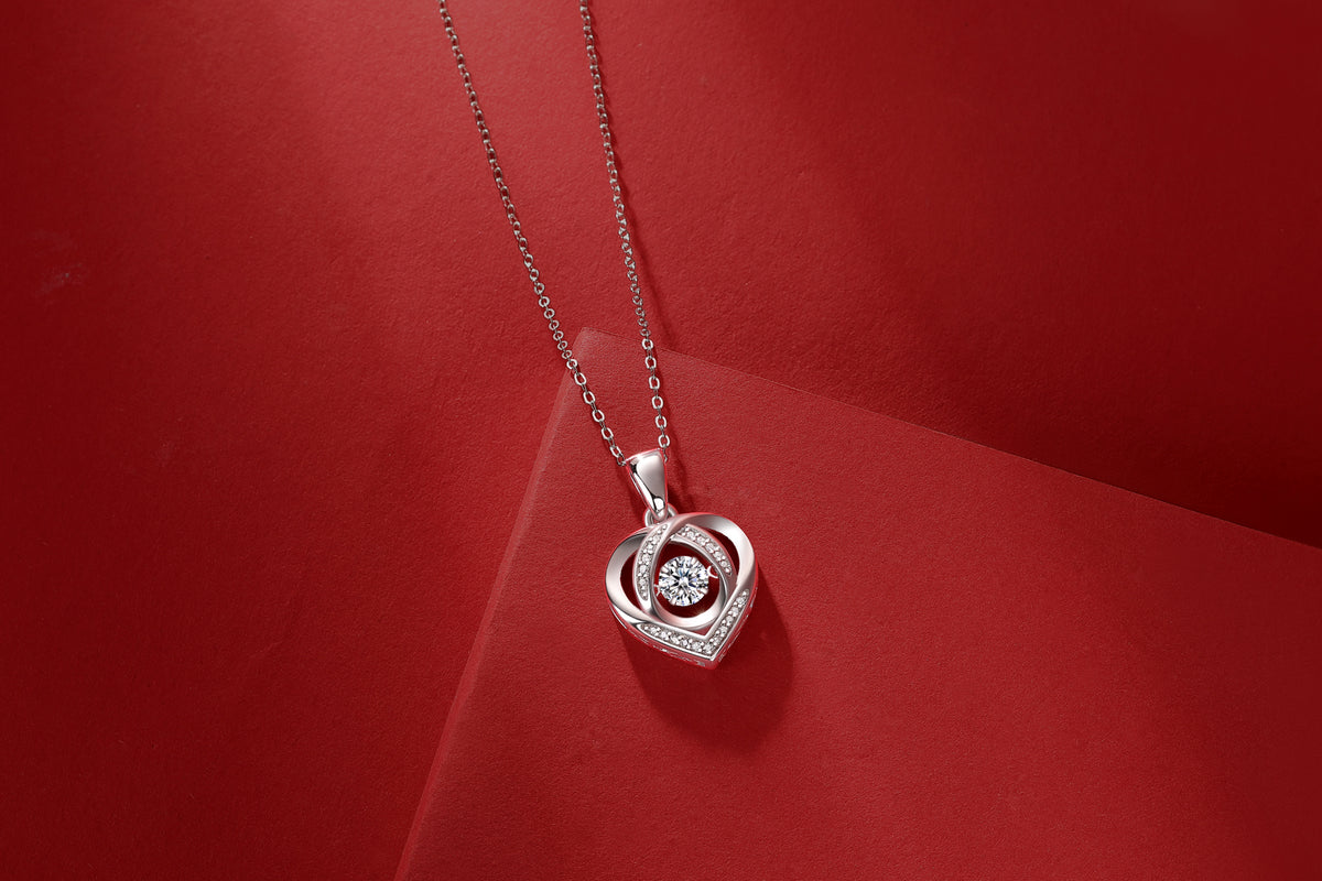 Elegant heart-shaped pendant necklace with sparkling stones on red background, luxury jewelry design
