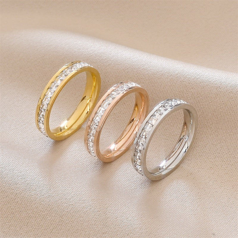 Elegant diamond-studded rings in gold, rose gold, and silver tones on soft fabric — minimalist luxury jewelry