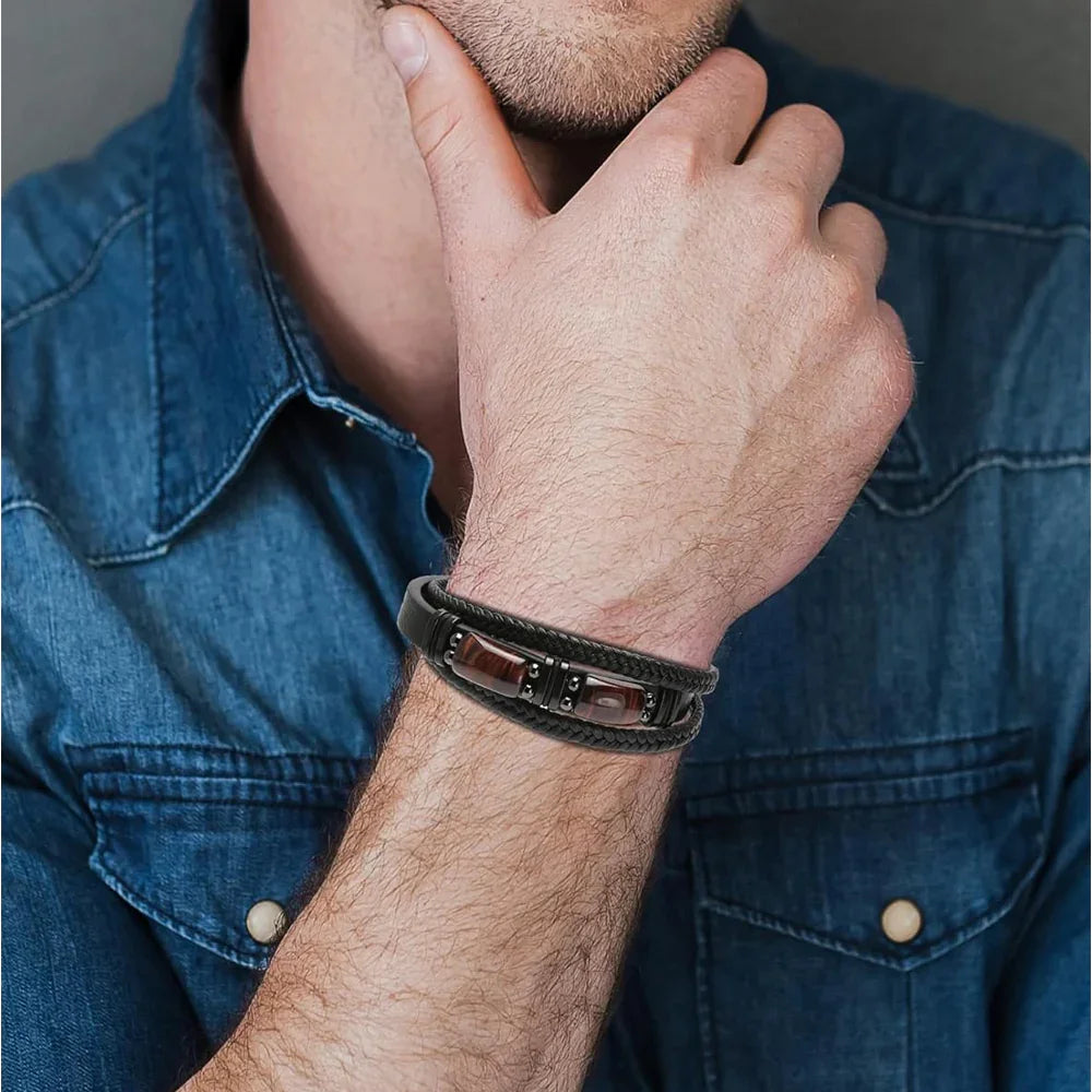 Men's black braided leather bracelet with amber stones, worn with denim shirt