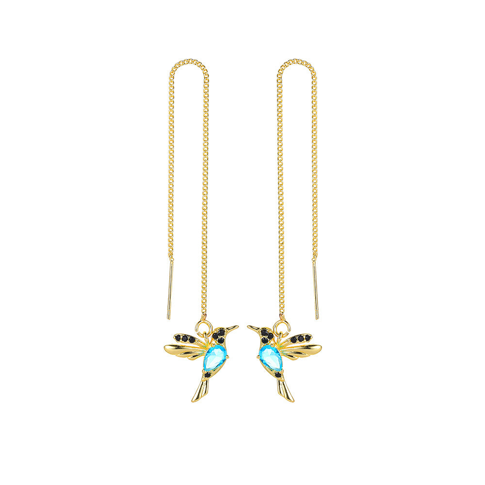 Gold hummingbird threader earrings with blue gemstone body and black crystal accents, minimalist luxury jewelry
