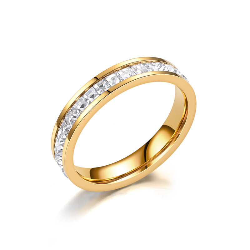 Gold band ring with channel-set princess-cut diamonds, minimalist luxury jewelry design