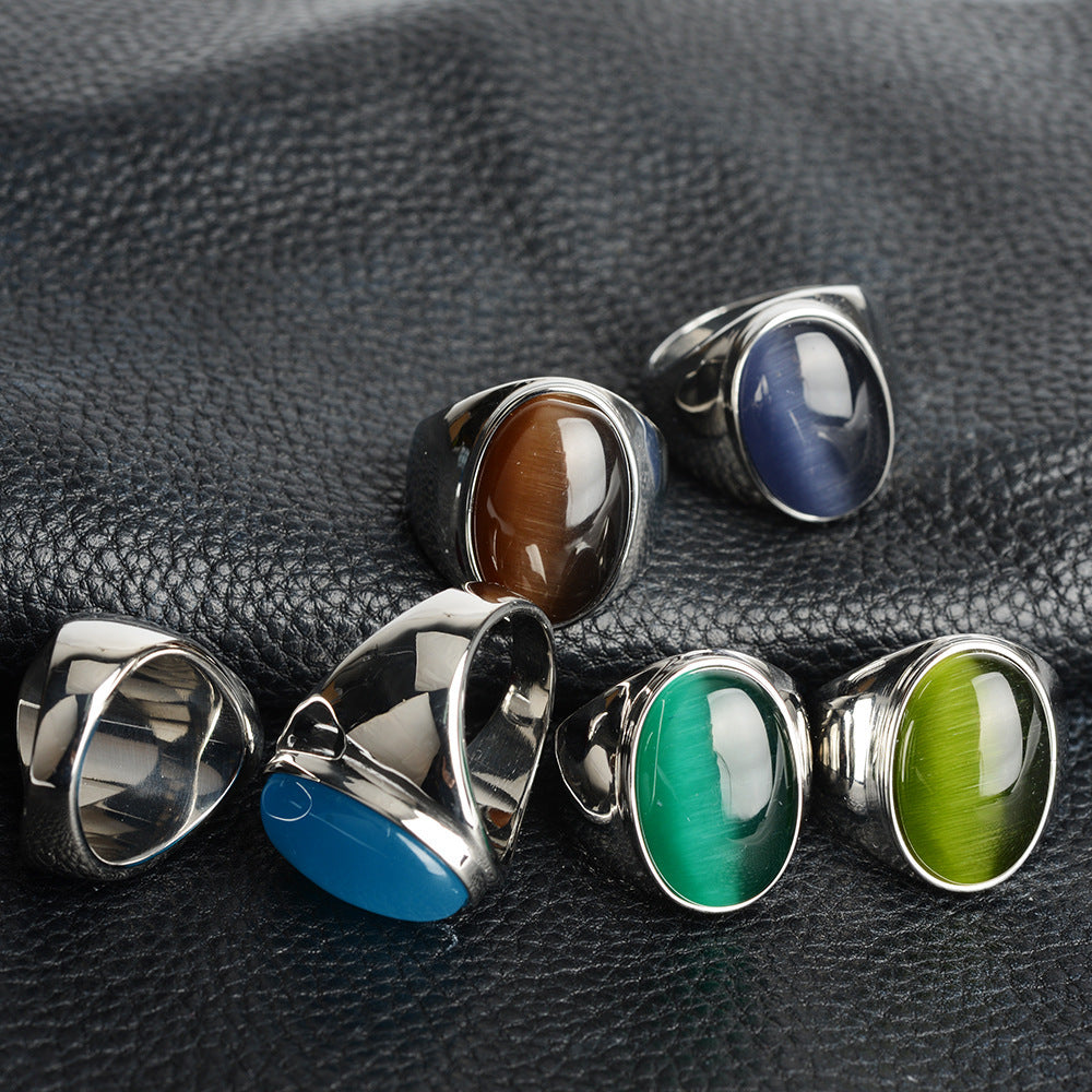 Luxury men's rings with oval gemstones in green, blue, brown, and teal on black leather