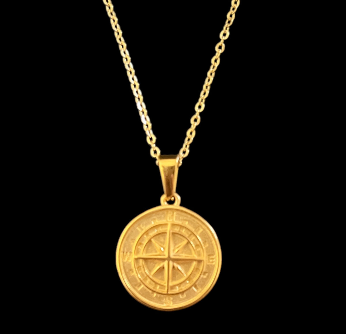 Gold compass pendant necklace with minimalist design, luxury jewelry piece on black background